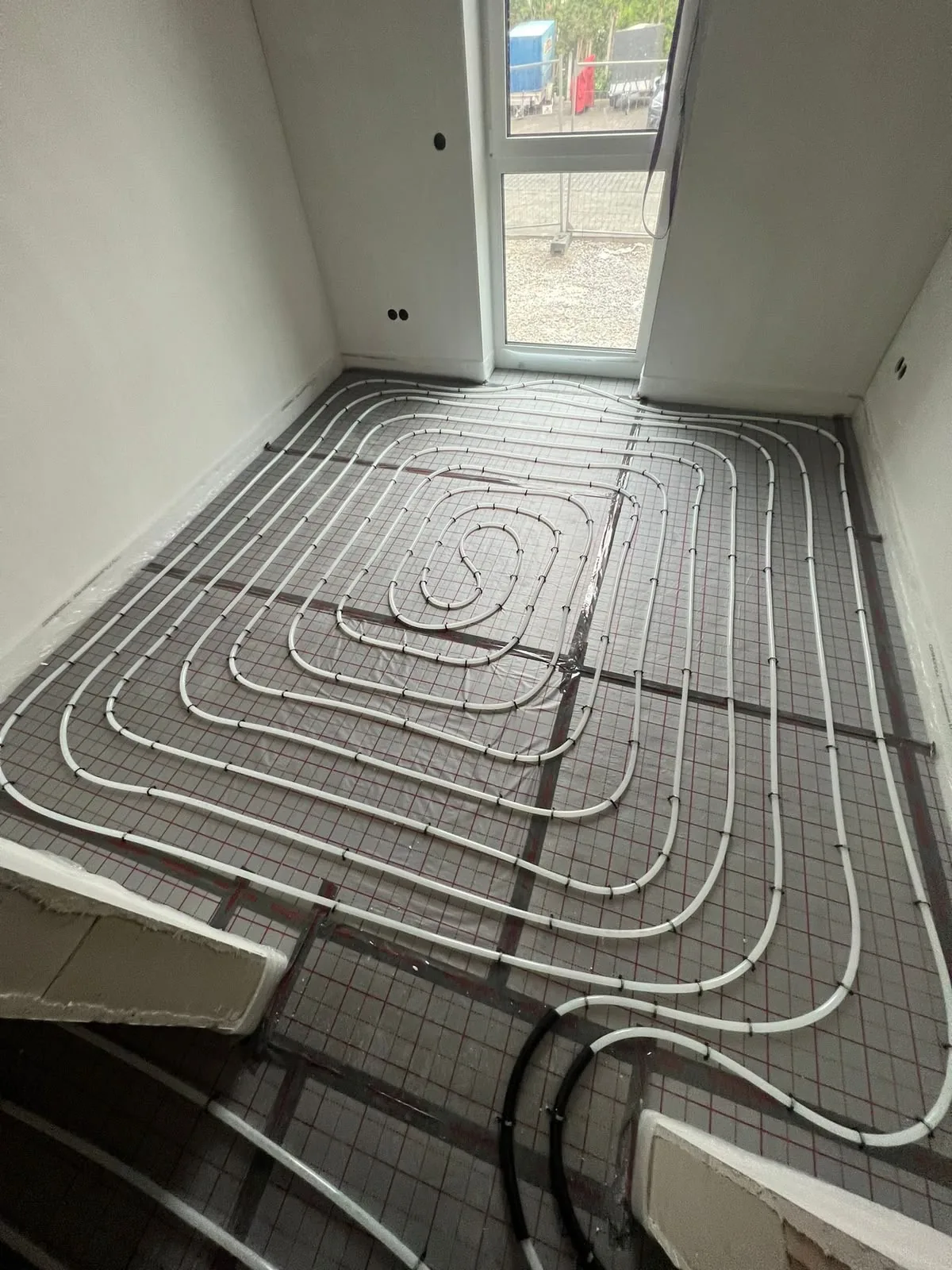 Verlegte Rohrschleifen einer Fußbodenheizung auf Dämmmatte in einem Neubau in Essen